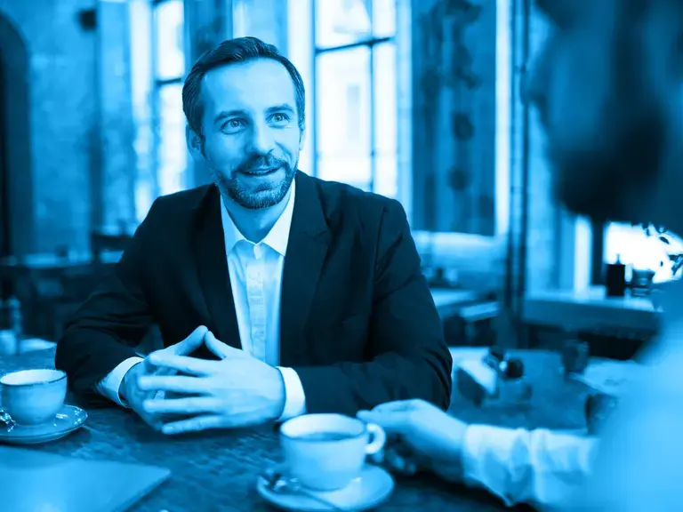 Zwei Männer an eine Tisch mit Kaffeetassen