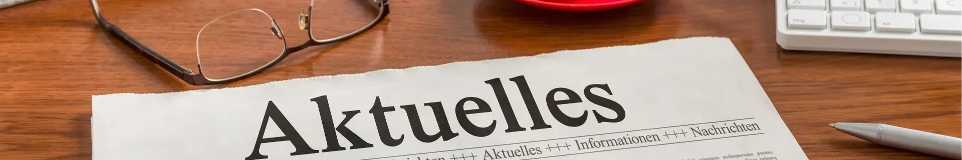 Eine Zeitung mit der Überschrift Aktuelles auf einem Tisch