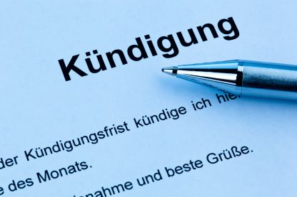 Ein Ausschnitt eines Papiers auf dem das Wort Kündigung steht. Darunter die Spitze eines Kugelschreibers